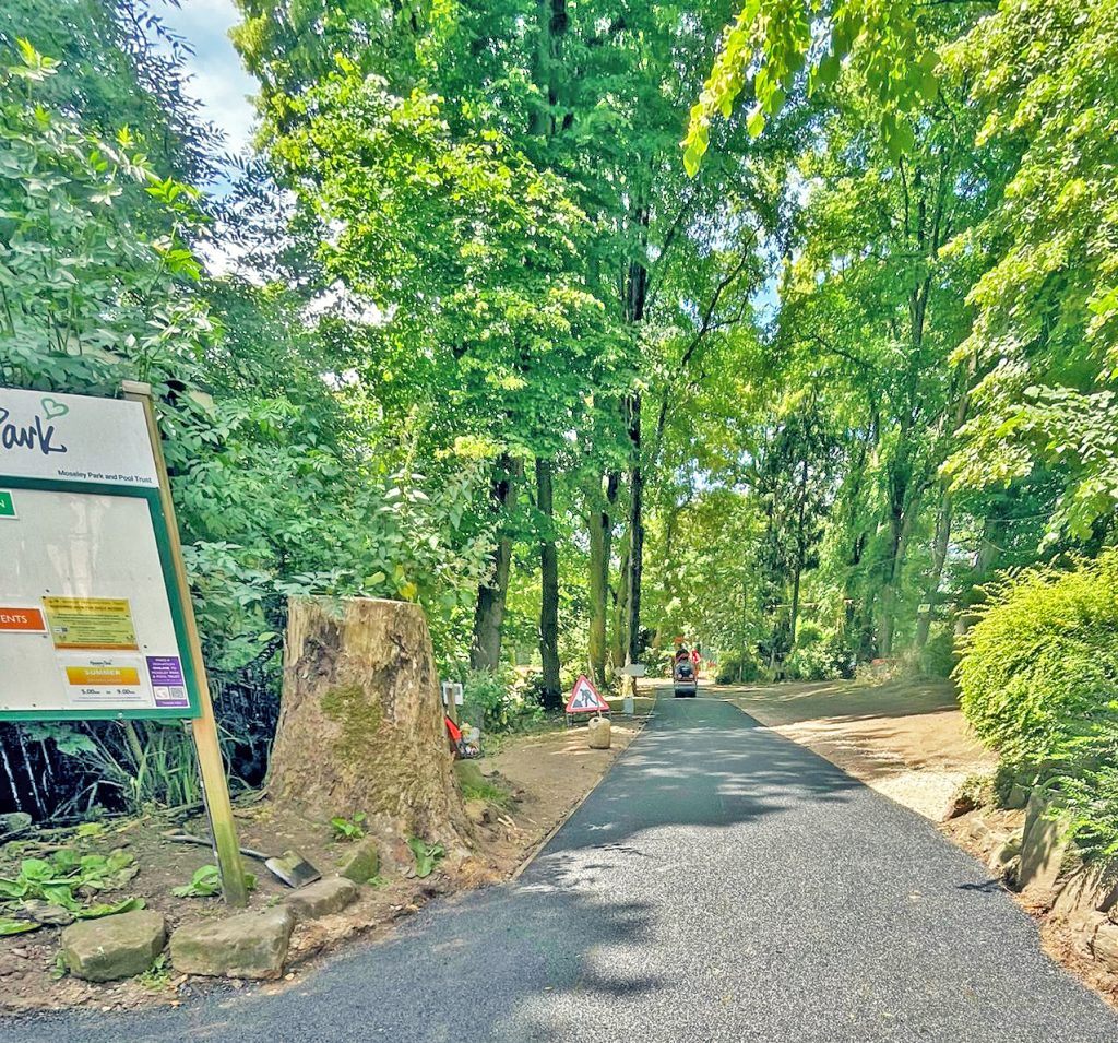 A photo of a new footpath inside the main gate with lots of lush green trees all around