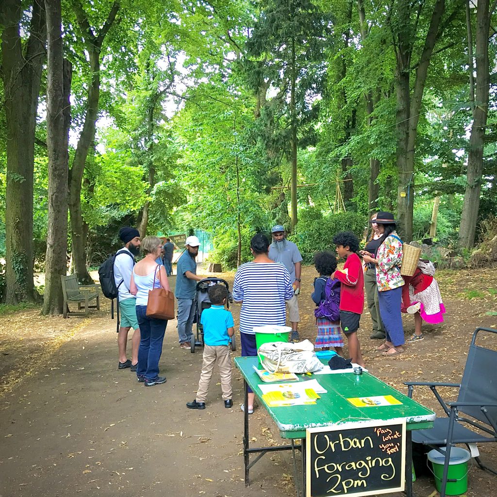 A photo of a group of people gathered under a high canopy of green trees