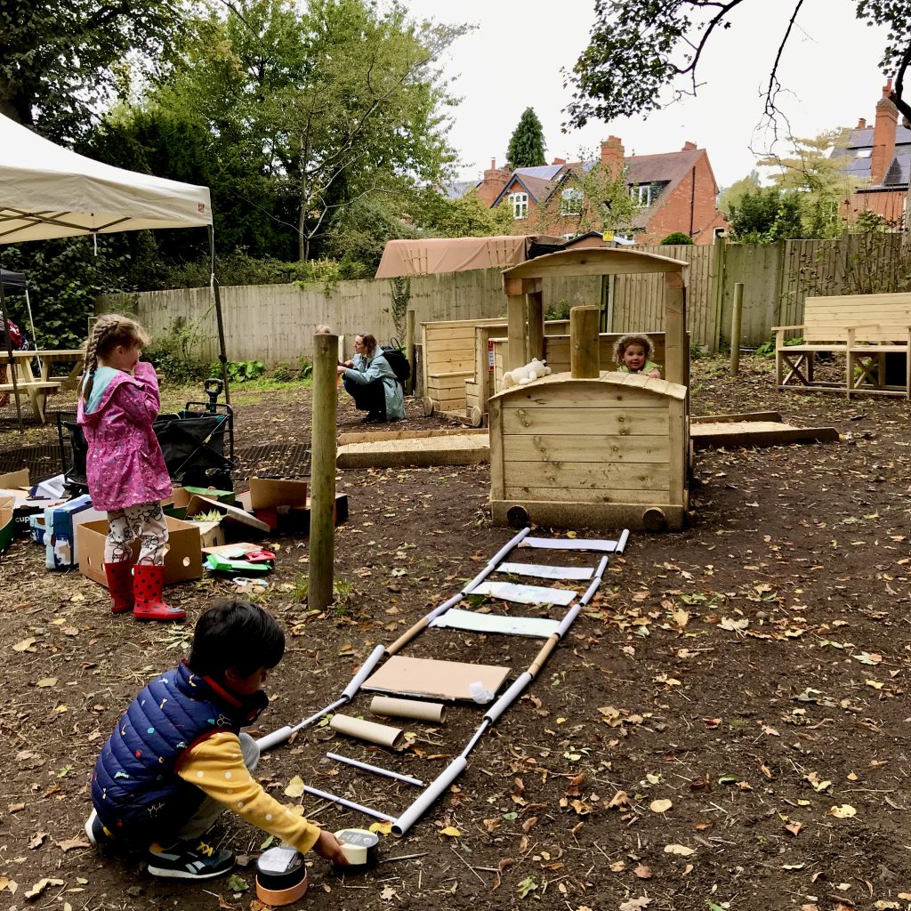 Children extend the track for our wooden train in the Phoenix accessible garden area